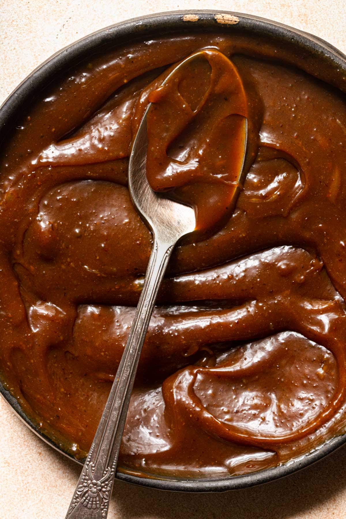 A bowl with pistachio flavored caramel and a spoon.
