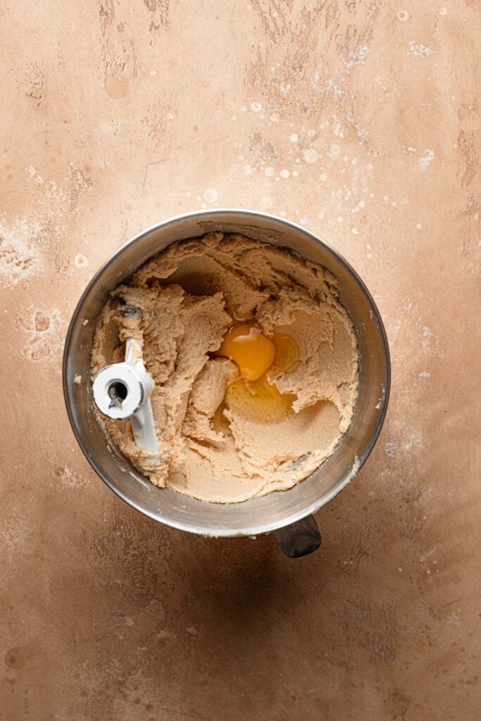 A mixing bowl with creamed butter and an egg.