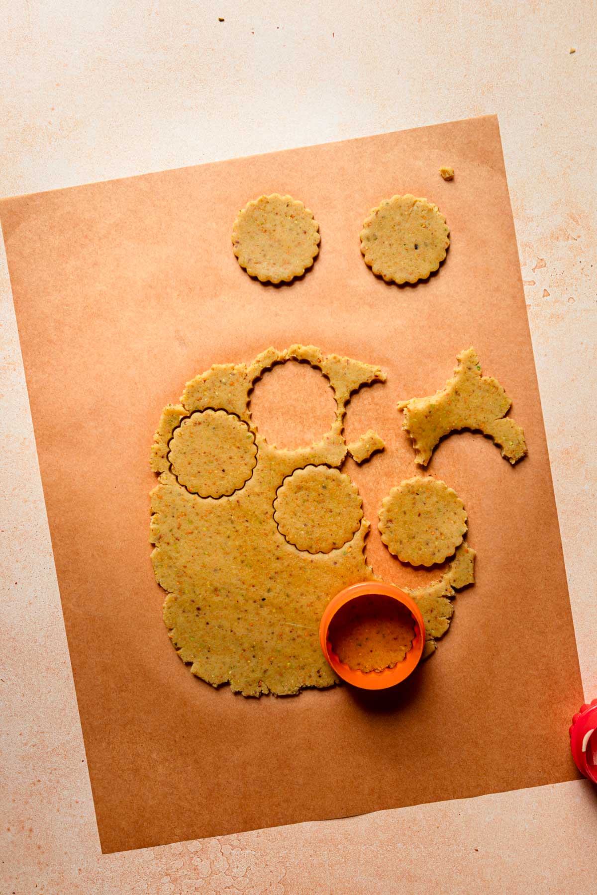 Parchment paper with rolled dough and a cookie cutter.