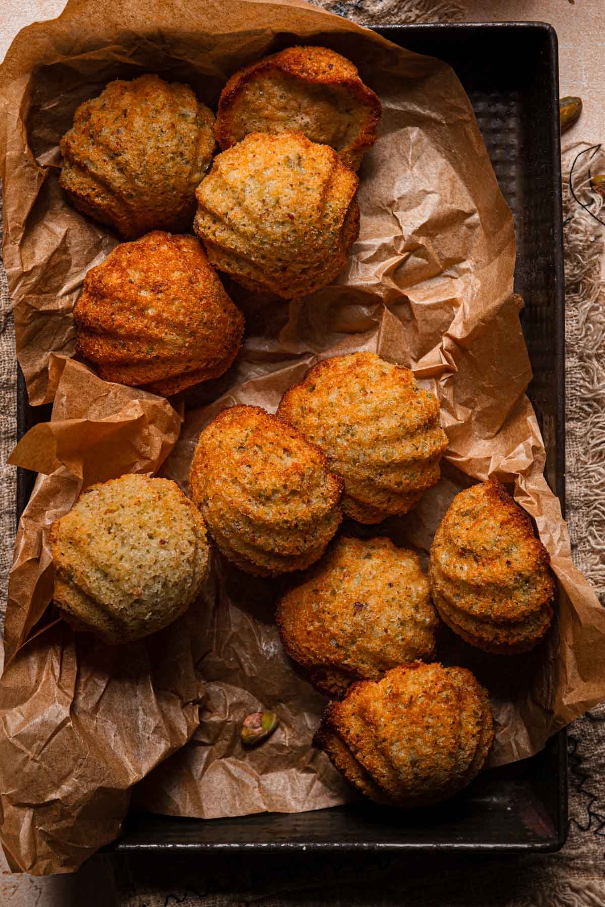Madeleines in a pan over parchment paper.