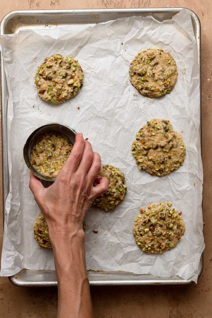 A hand swirling cookie using a cookie cutter.