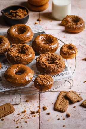 Pumpkin donuts with Biscoff glaze on a wire rack.