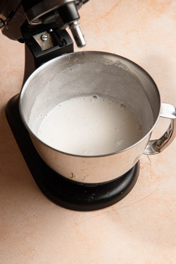 A stand mixer with a bowl full of soft meringue.