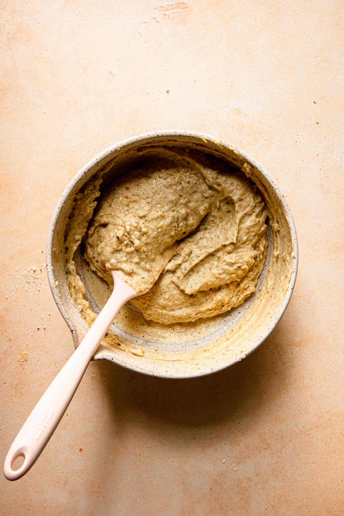 a mixing bowl with a cake batter and a spatual.