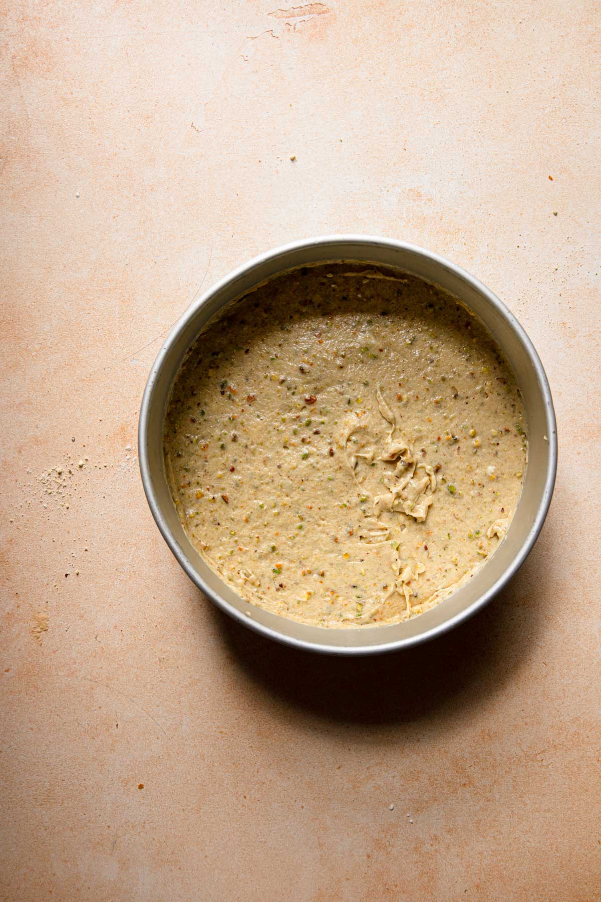 A pan with unbaked pistachio cake batter.