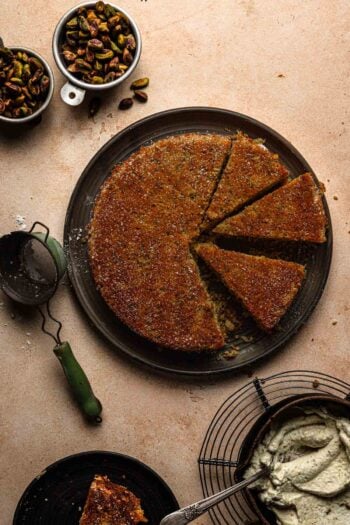 sliced pistachio torte with whipped cream in a bowl.