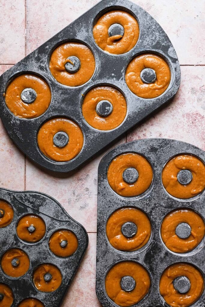 Donut mold filled with pumpkin batter.