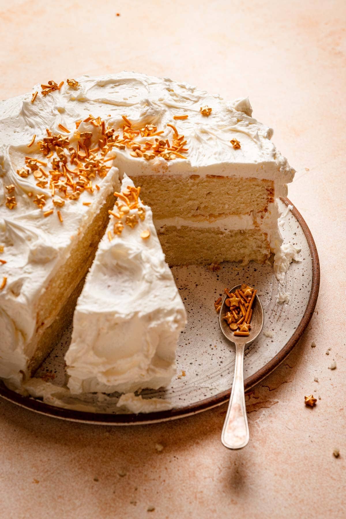 Vanilla bean cake topped with buttercream and gold sprinkles.