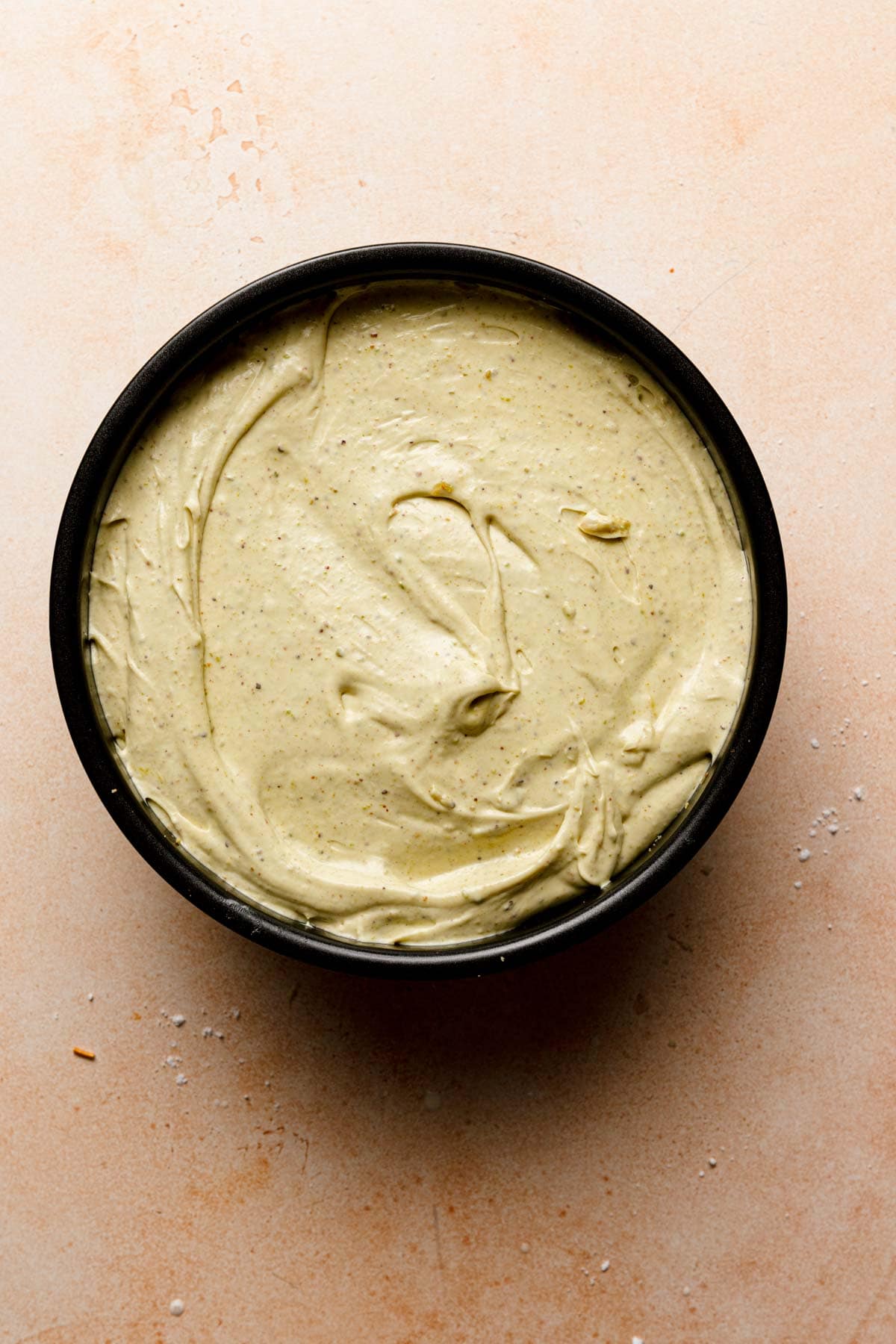 Pistachio cheesecaks batter in a pan.