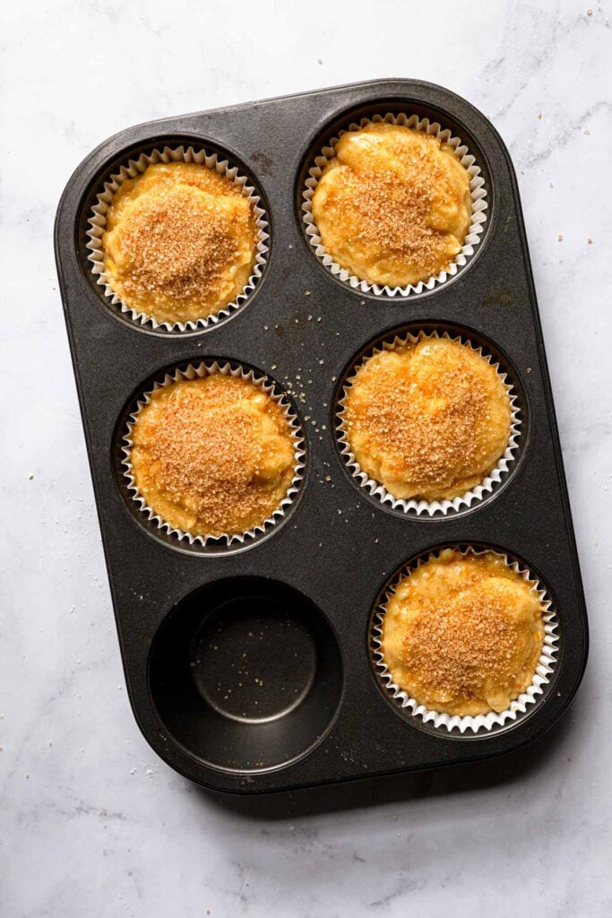 A muffin tin with raw muffin batter.