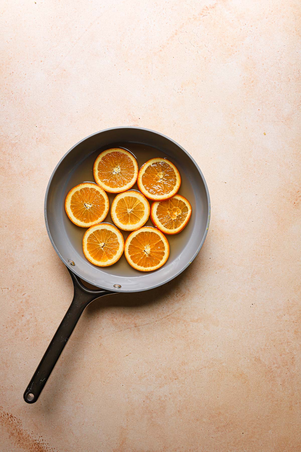 A pan with water and orange slices.