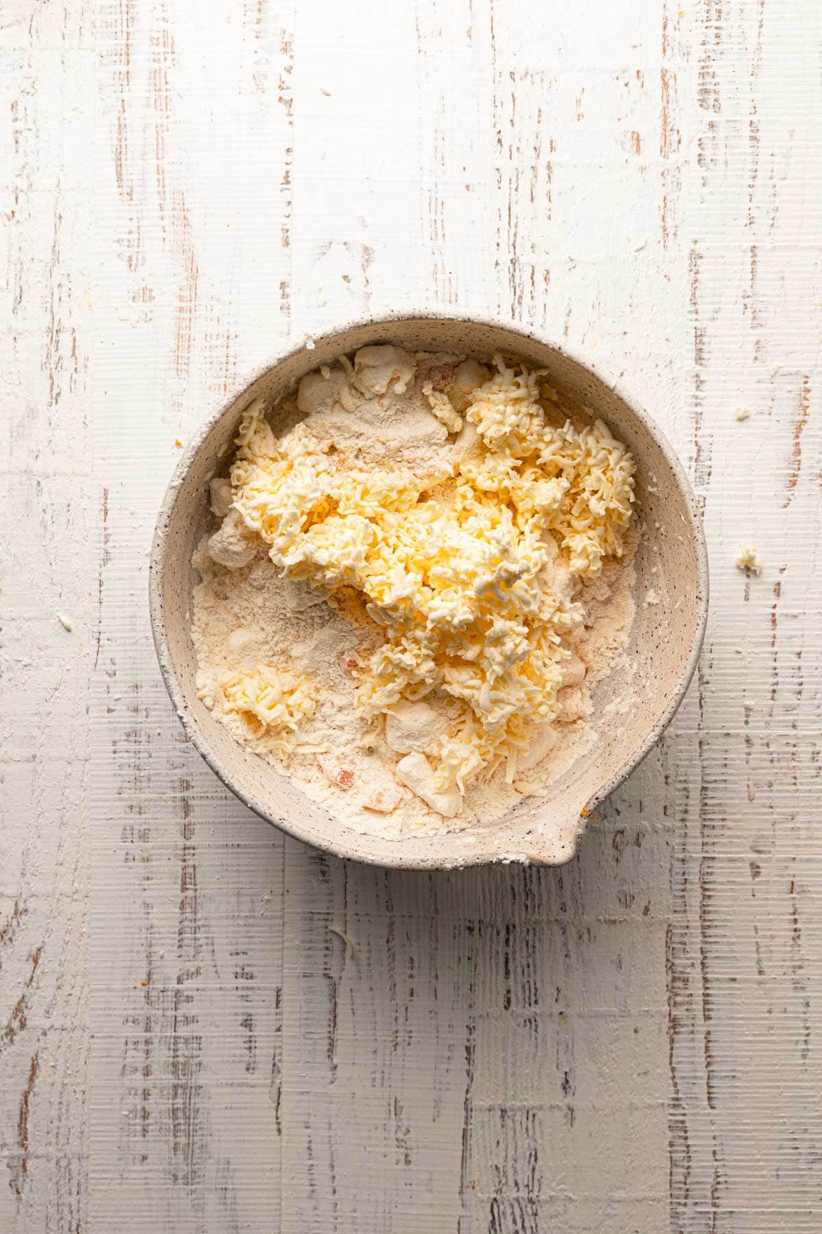 A large bowl with flour and grated butter.