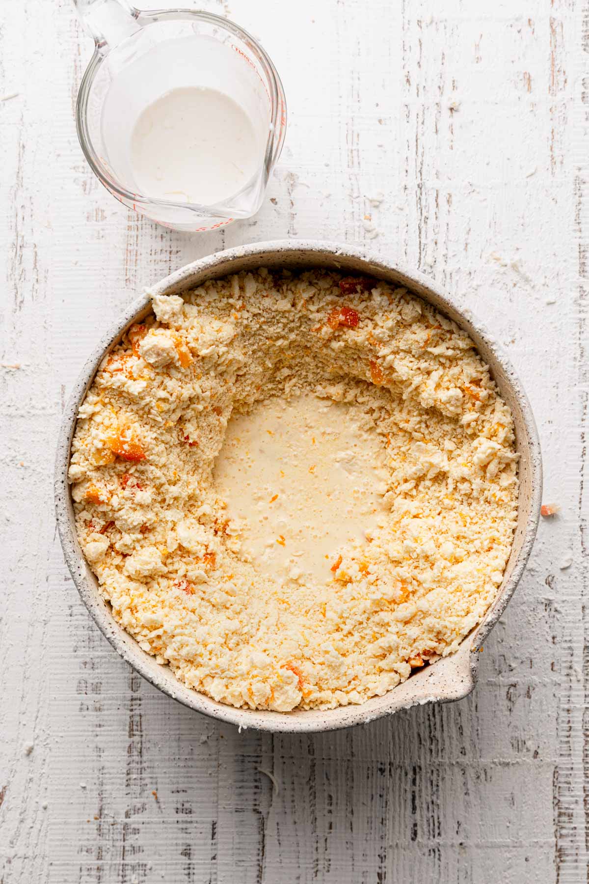 A bowl with flour mixer and milk at the center.