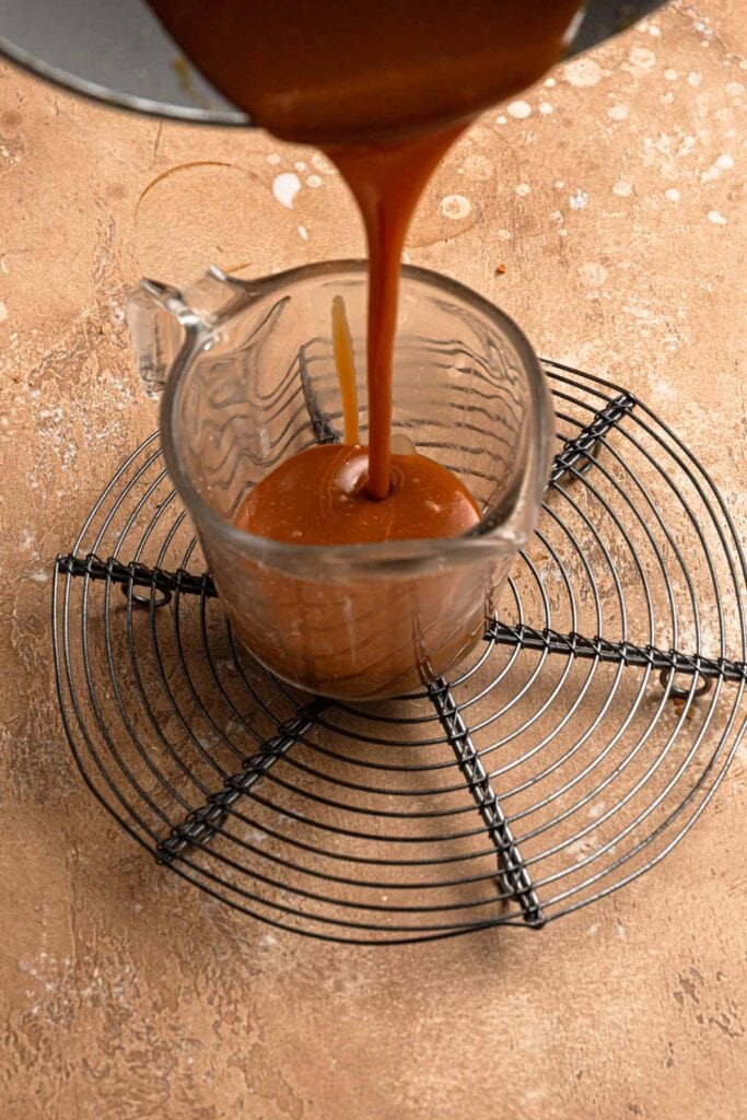 Pouring caramel into a glass cup.