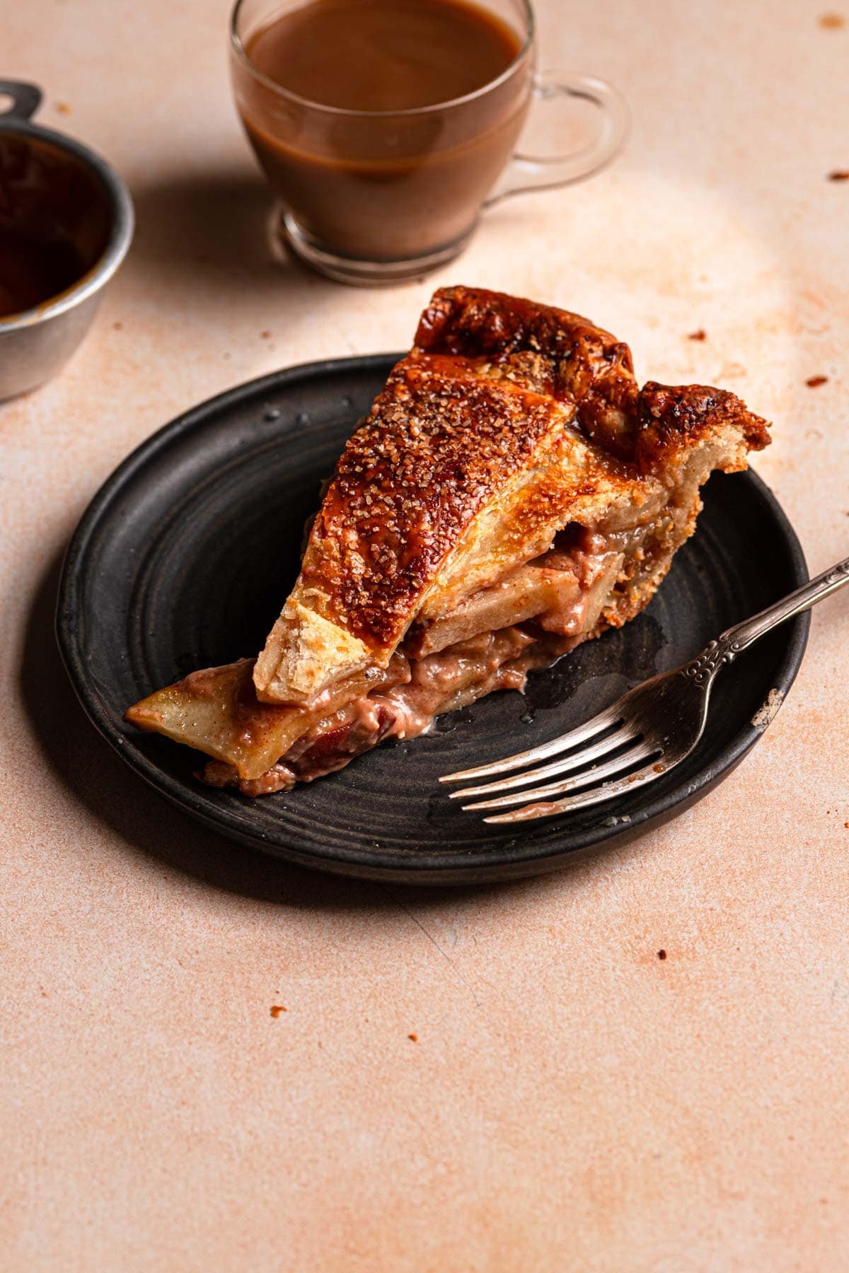 A pear caramel slice on a plate with a fork.