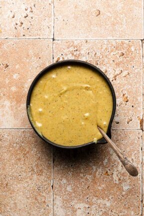 Pistachio glaze in a bowl with a spoon.