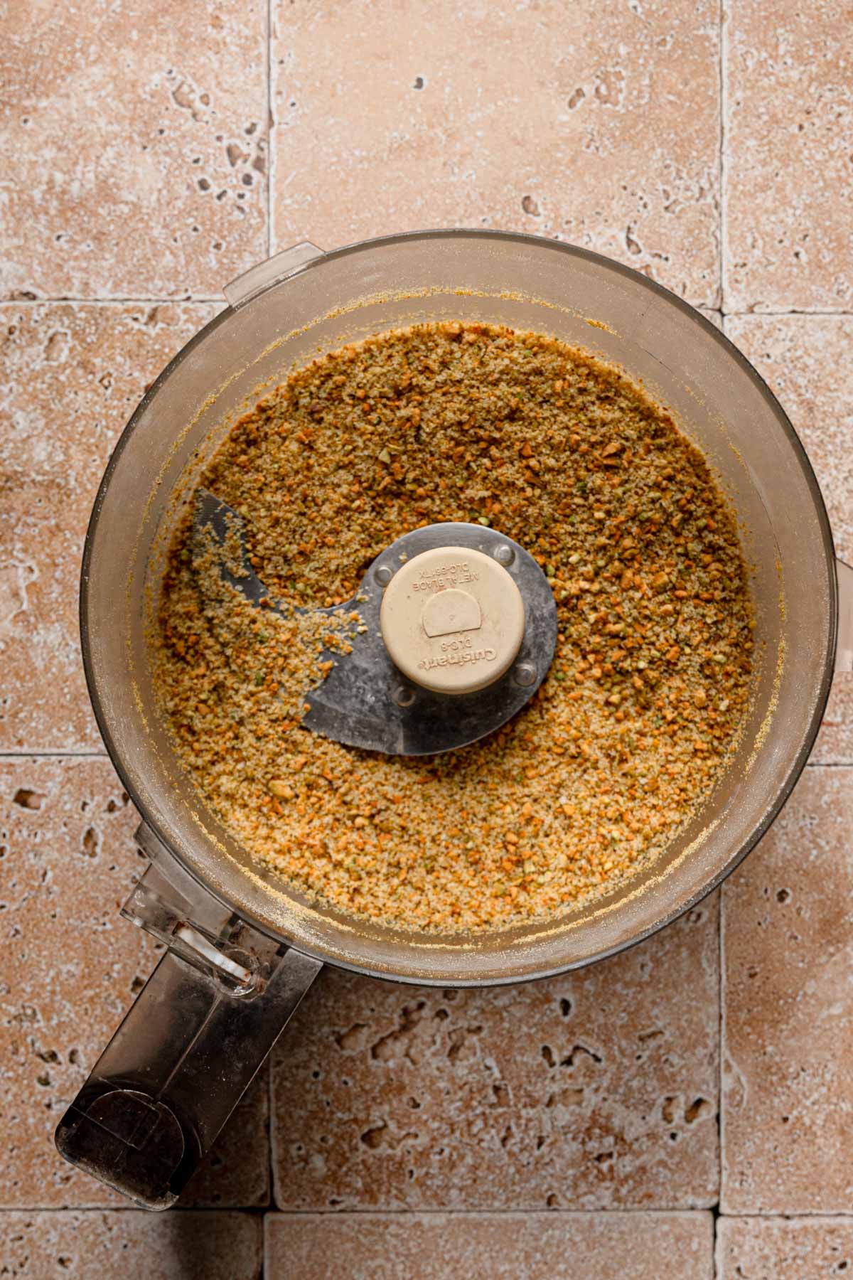 A food processor with fine pistachios.