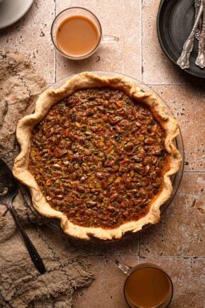Pistachio pie with cups of coffees plates and forks.