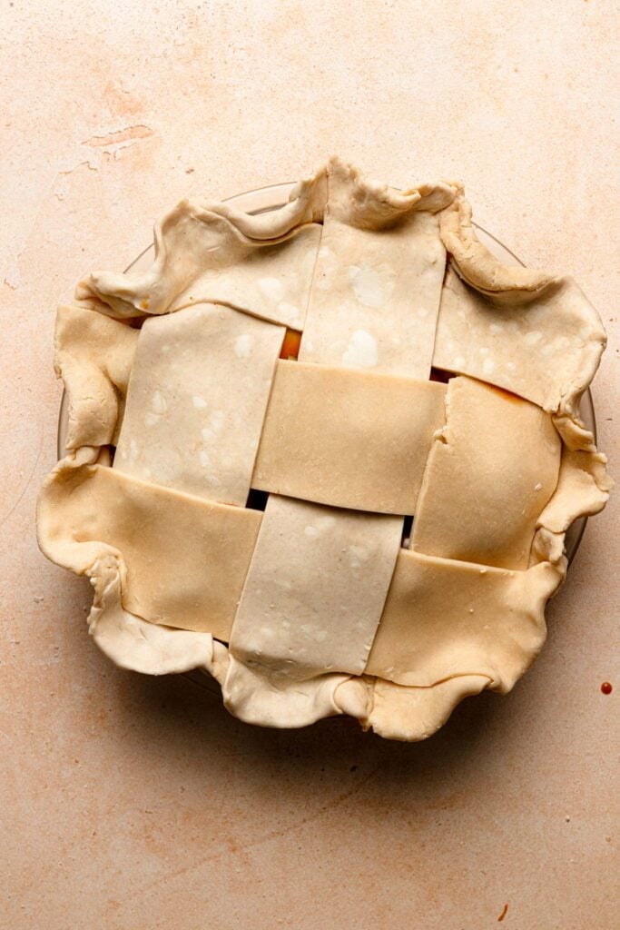 Unbaked pie topped with lattice decoration.