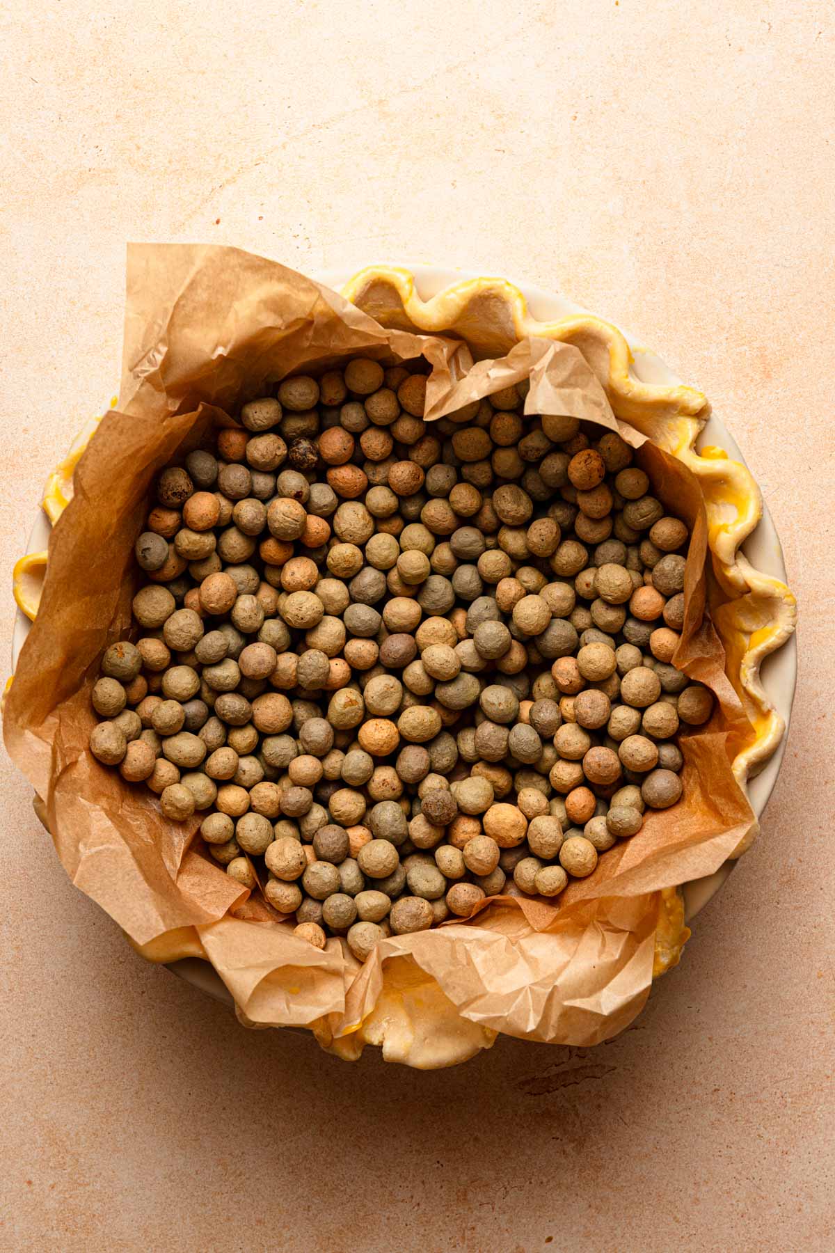 Pie crust topped with pie weights.