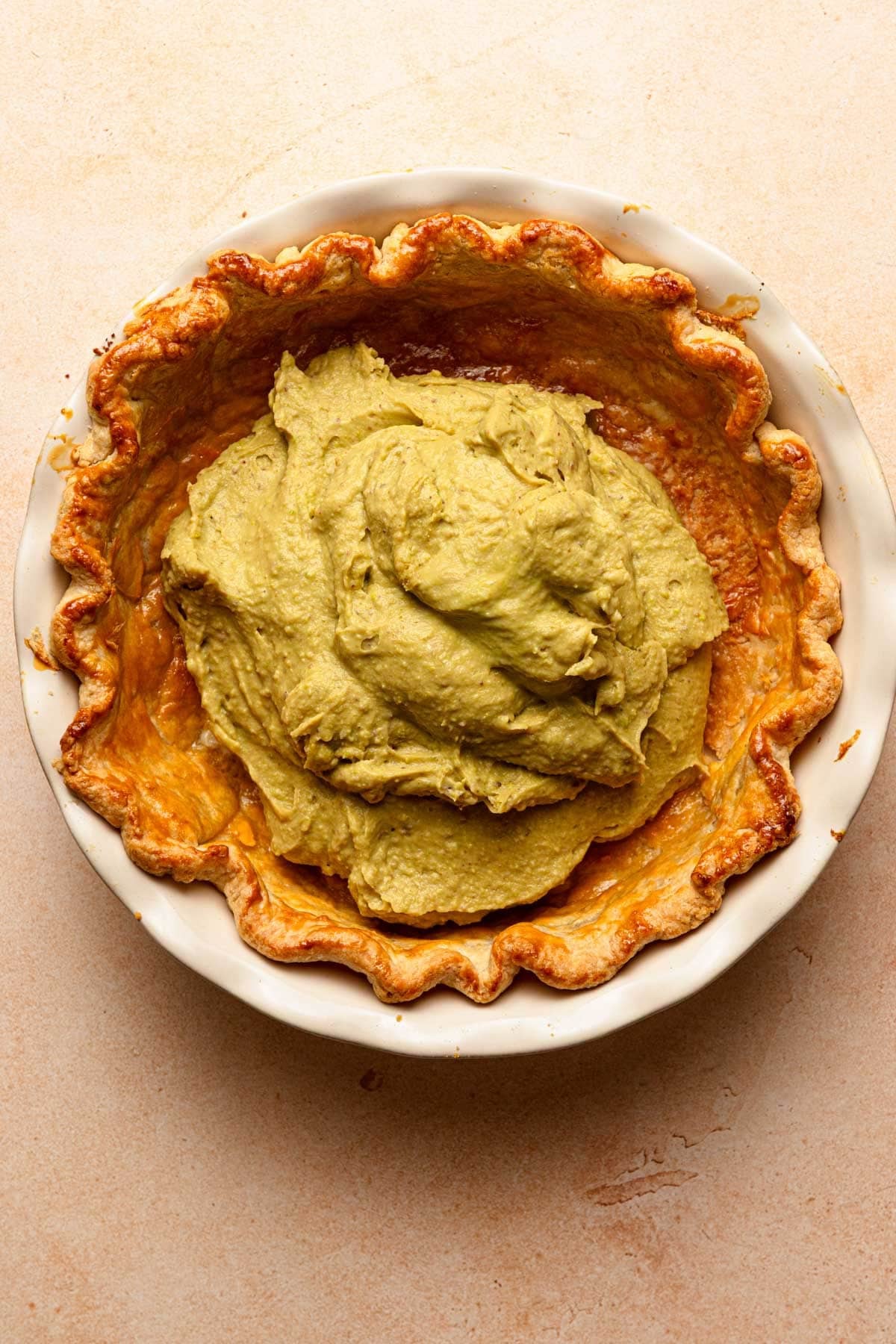 Pie crust topped with pistachio pastry cream.