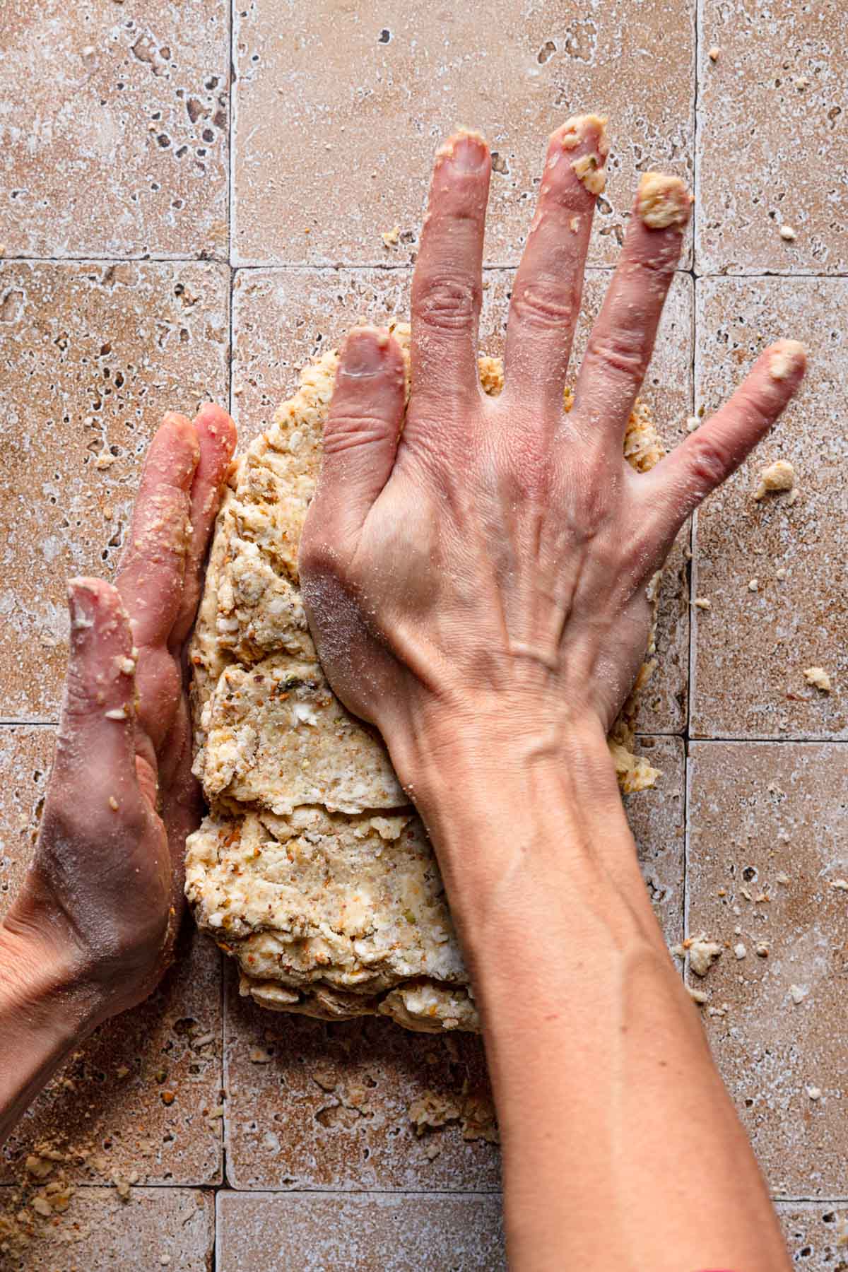 Hands pressing dough.