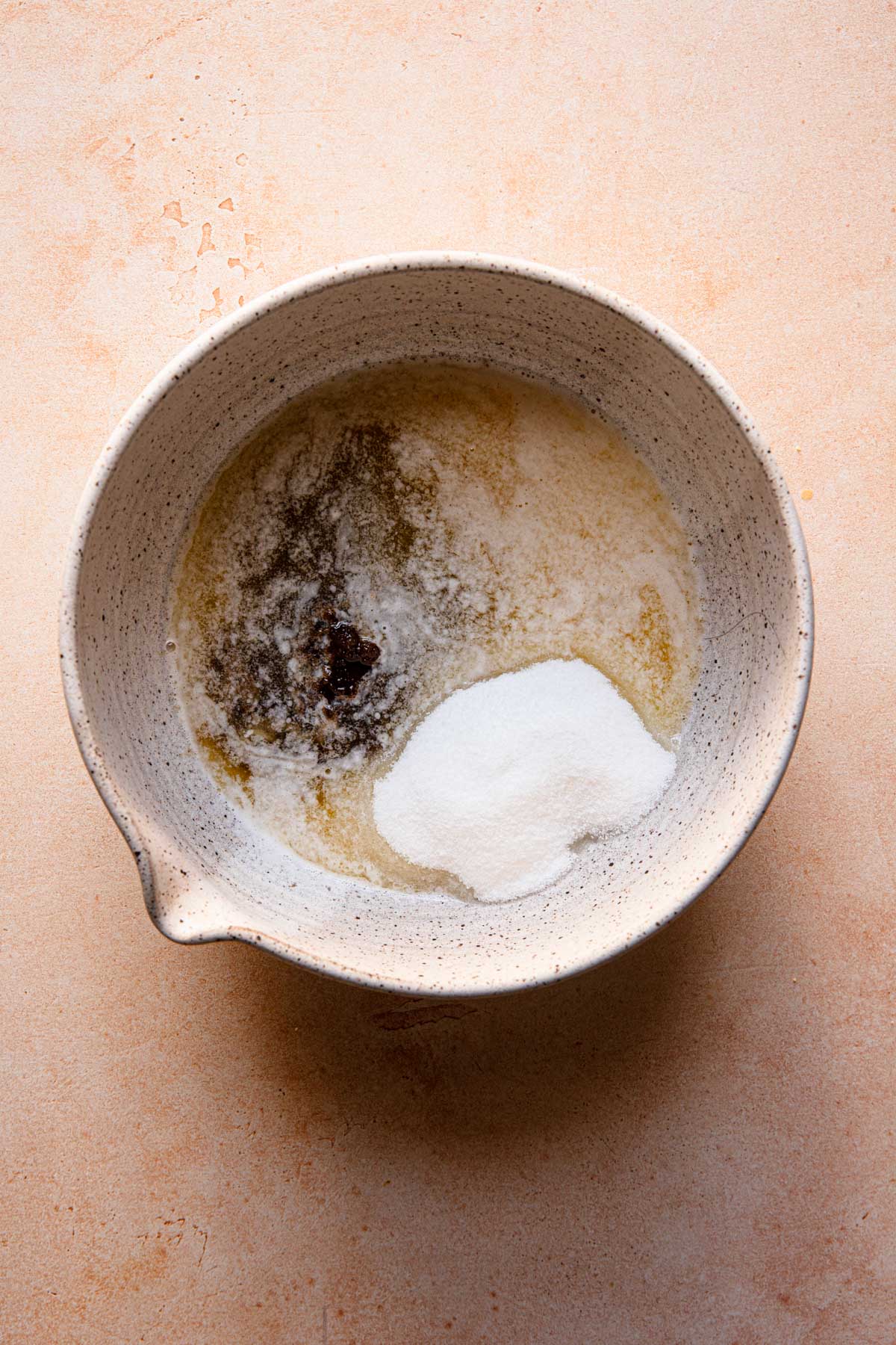 A large bowl with melted butter, and sugar.