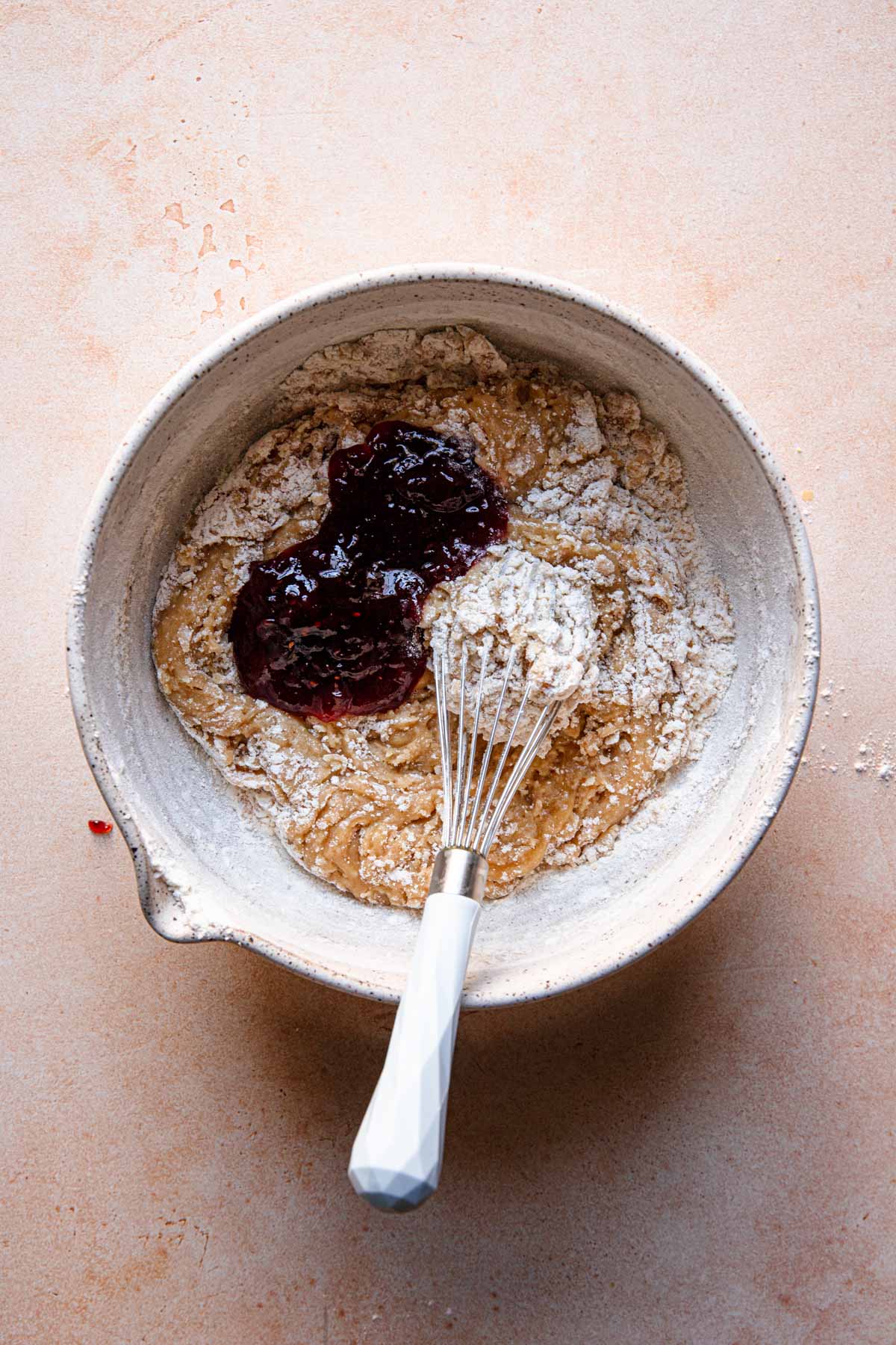A large bowl with dough and a whisk.