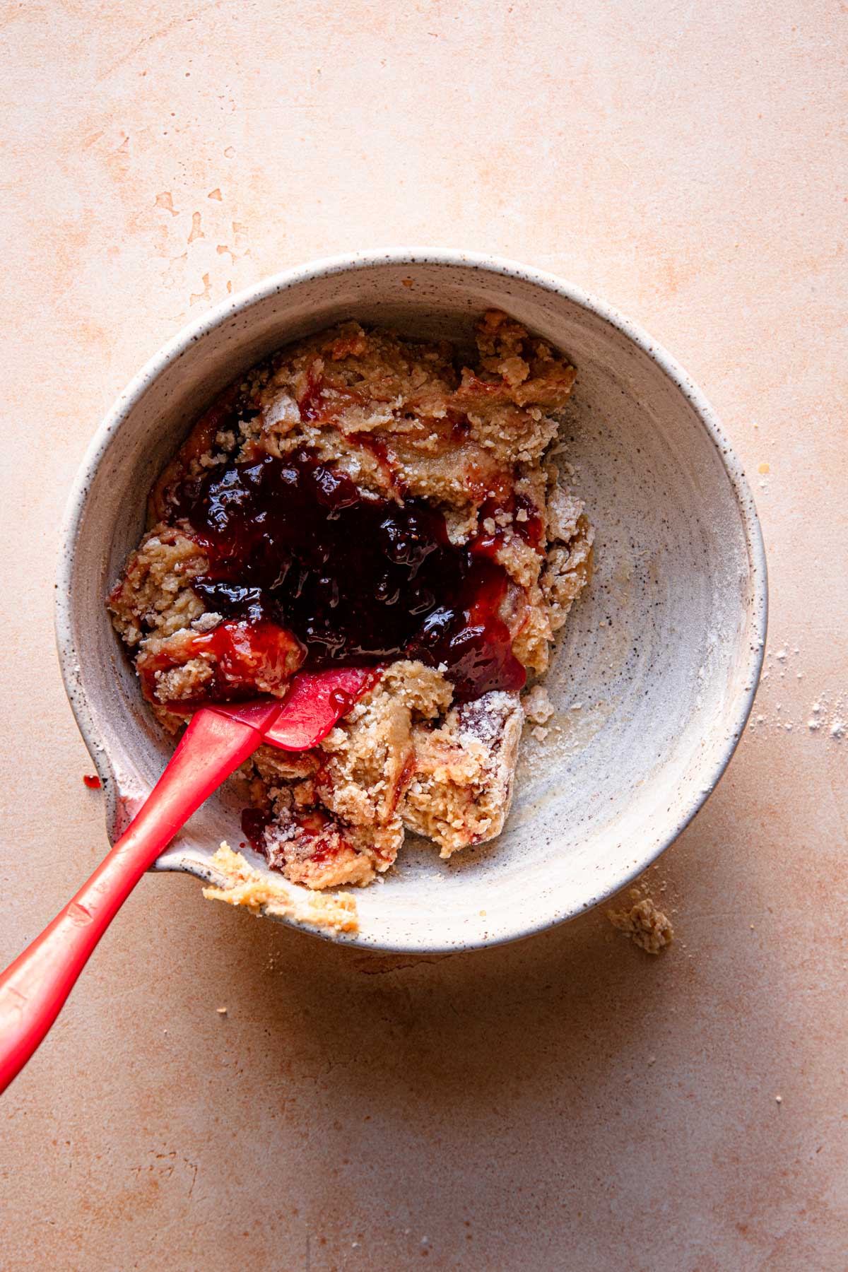 A large bowl with dough and a rubber spatula.