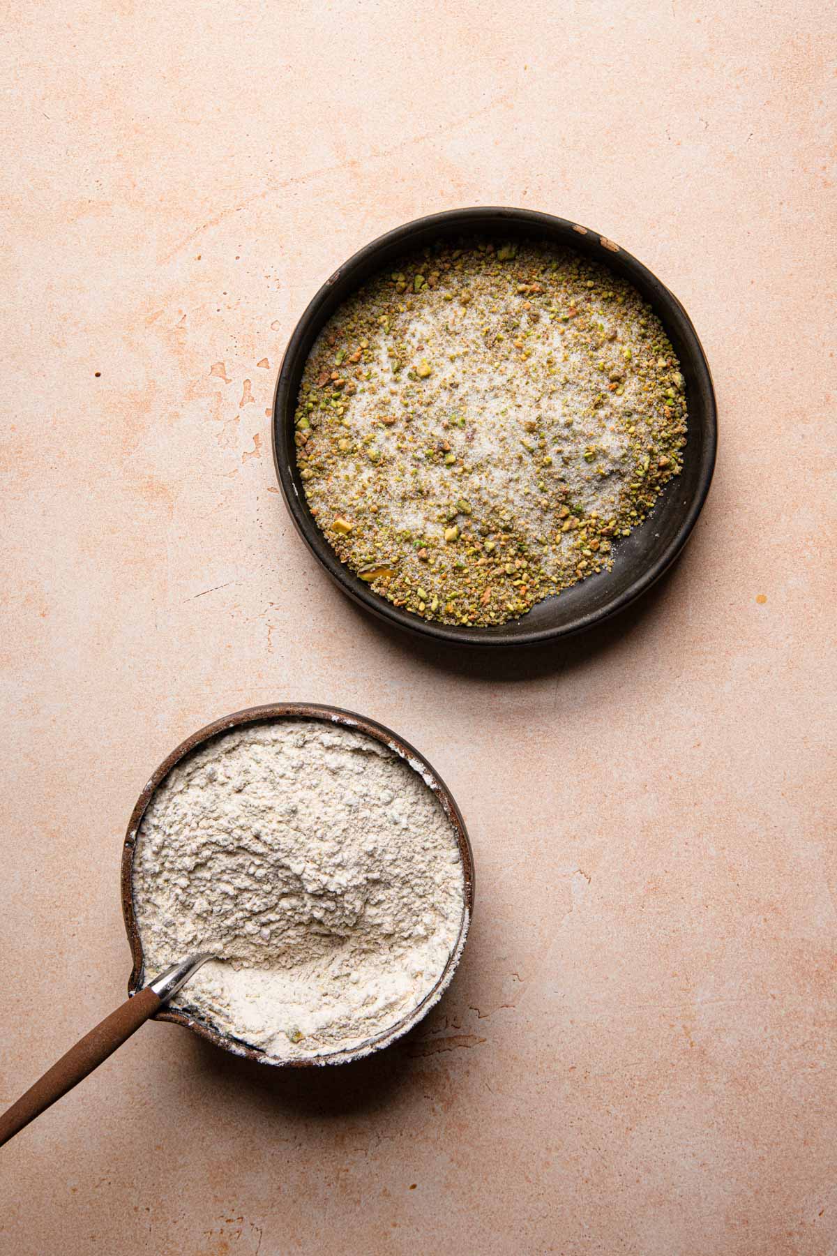 a bowl with sugar pistachio and another bowl with flour mixture.