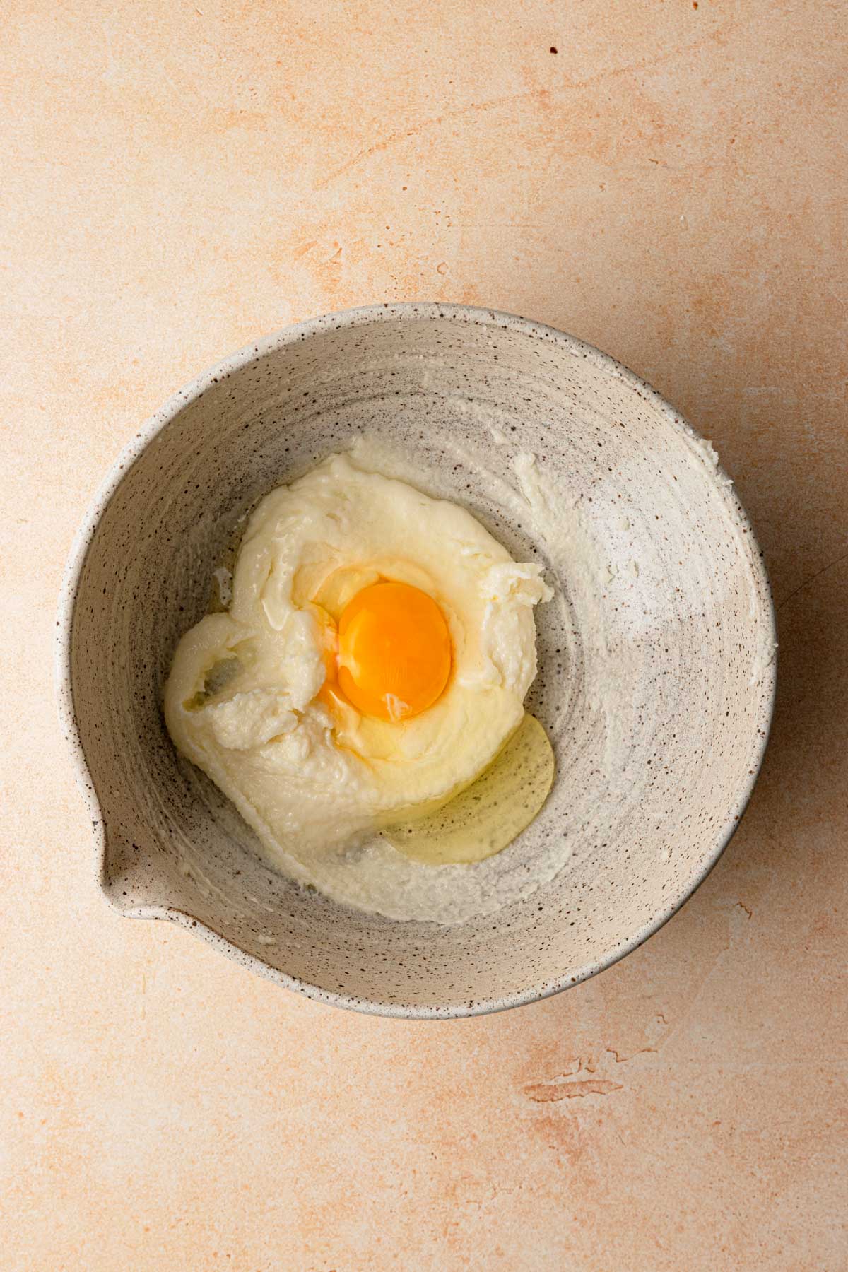 A large bowl with cream butter and sugar and an egg.