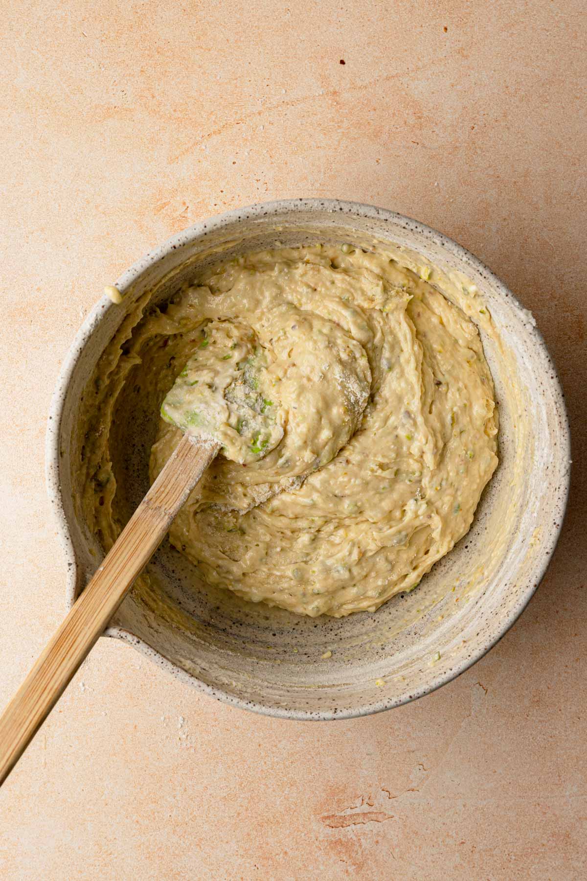 A large bowl raw batter with a rubber spatula.