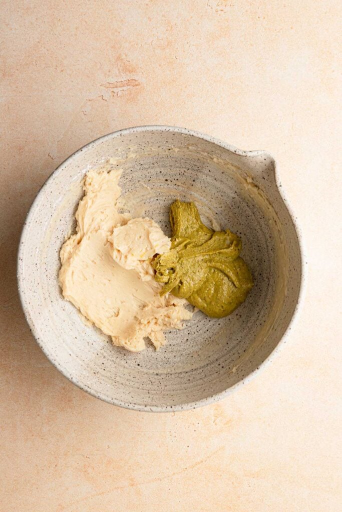 A large bowl with creamed butter and pistachio cream.