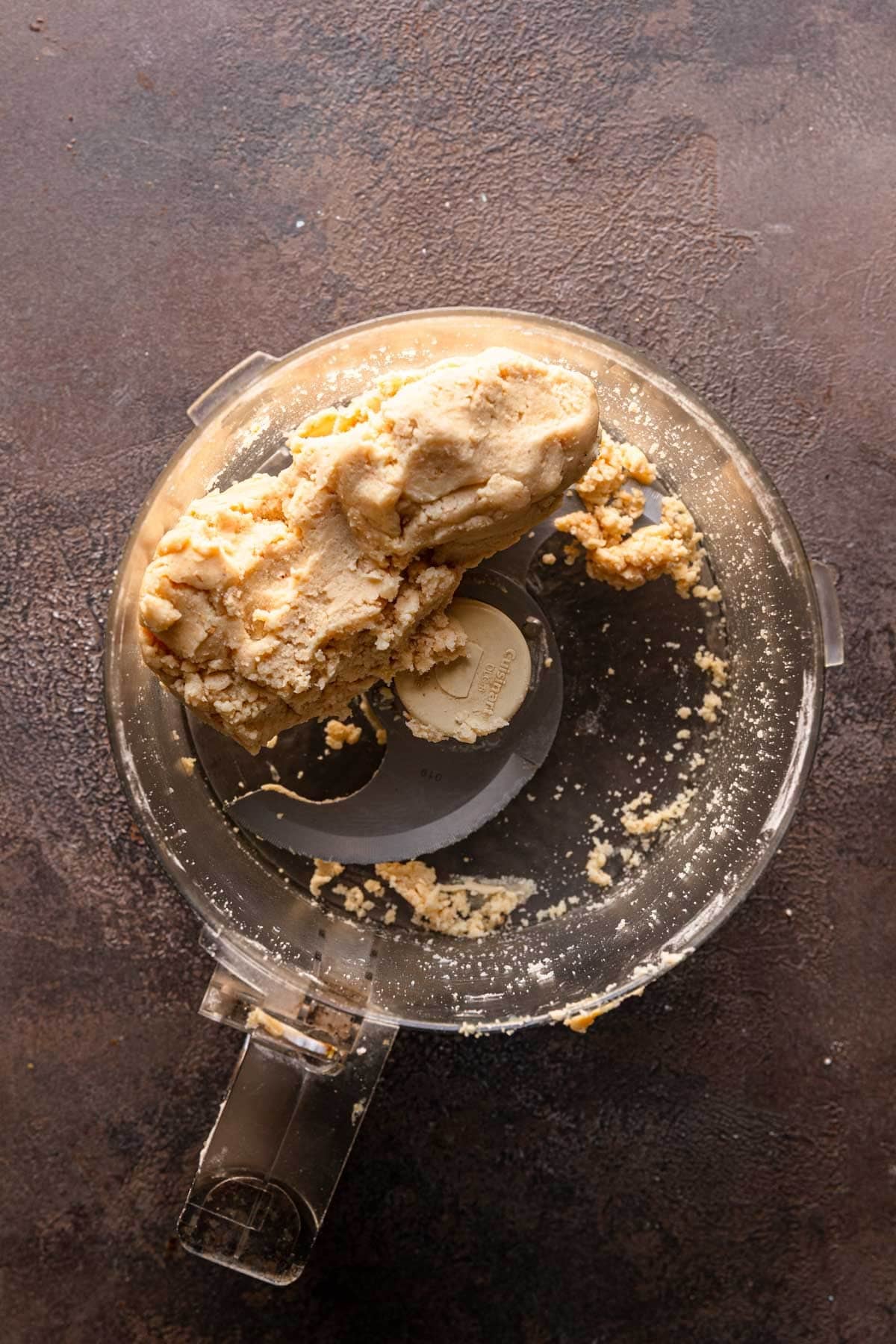 A food processor bowl with cookie dough,