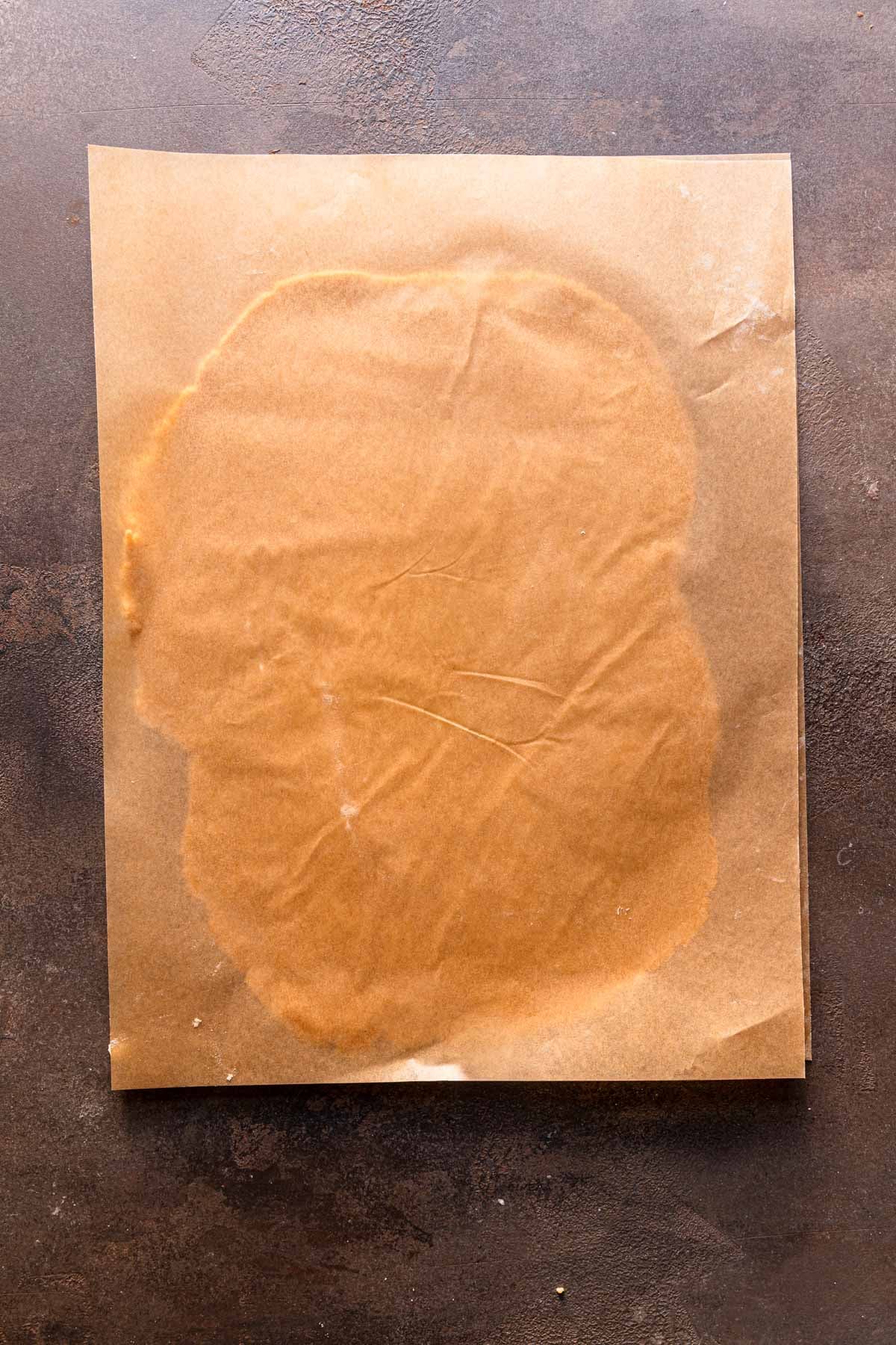 Rolled cookie dough between two pieces of parchment paper.