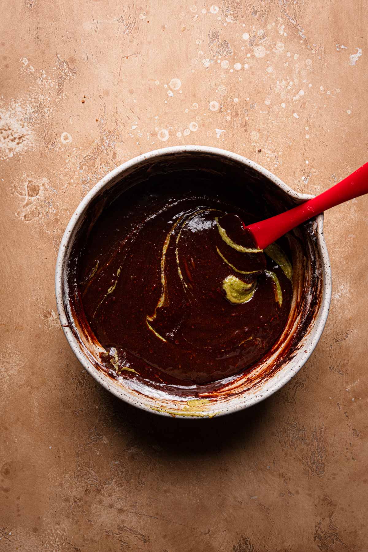 a bowl with melted chocolate and a spatula pistachio cream.