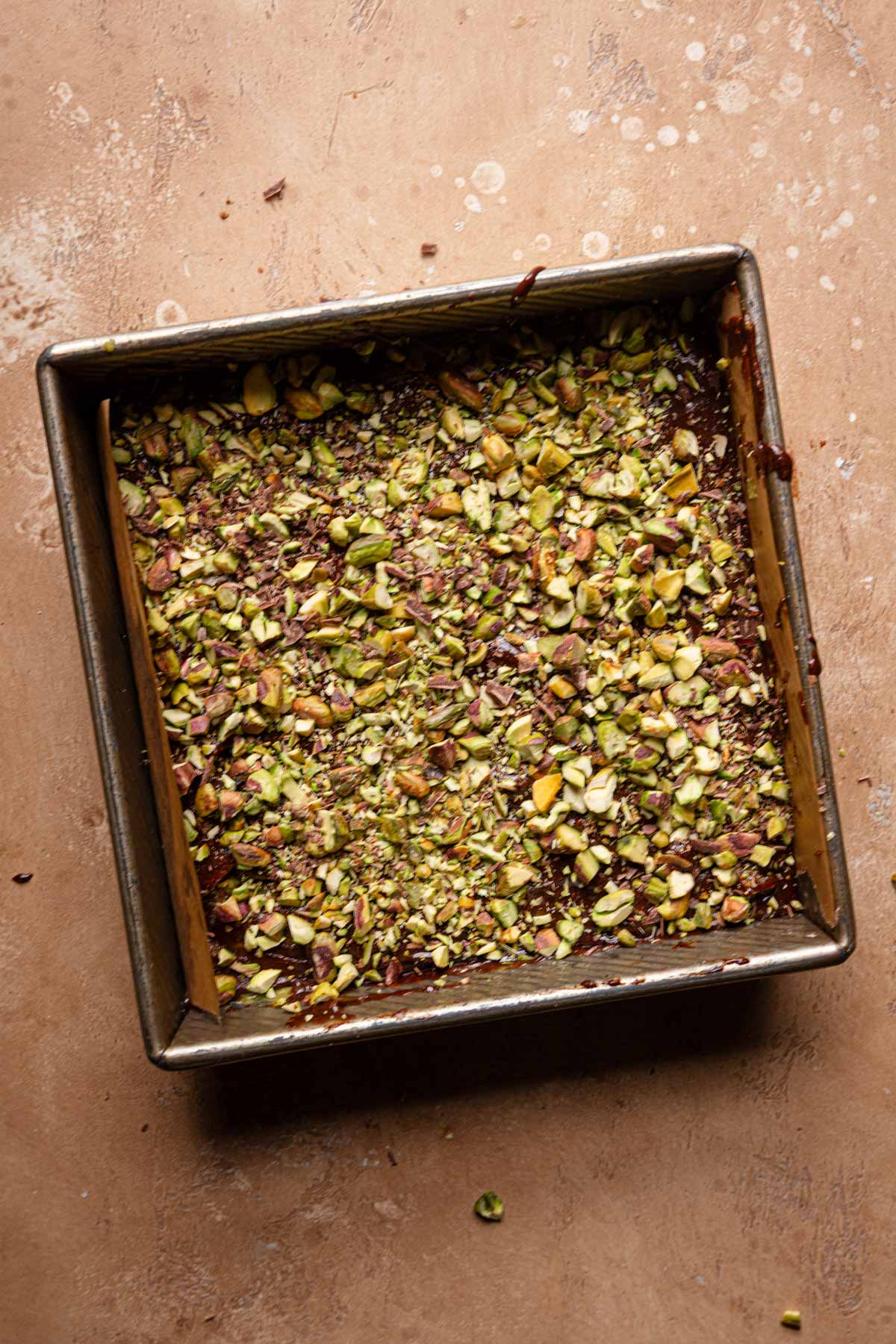 Brownie topped with chopped pisatchios.