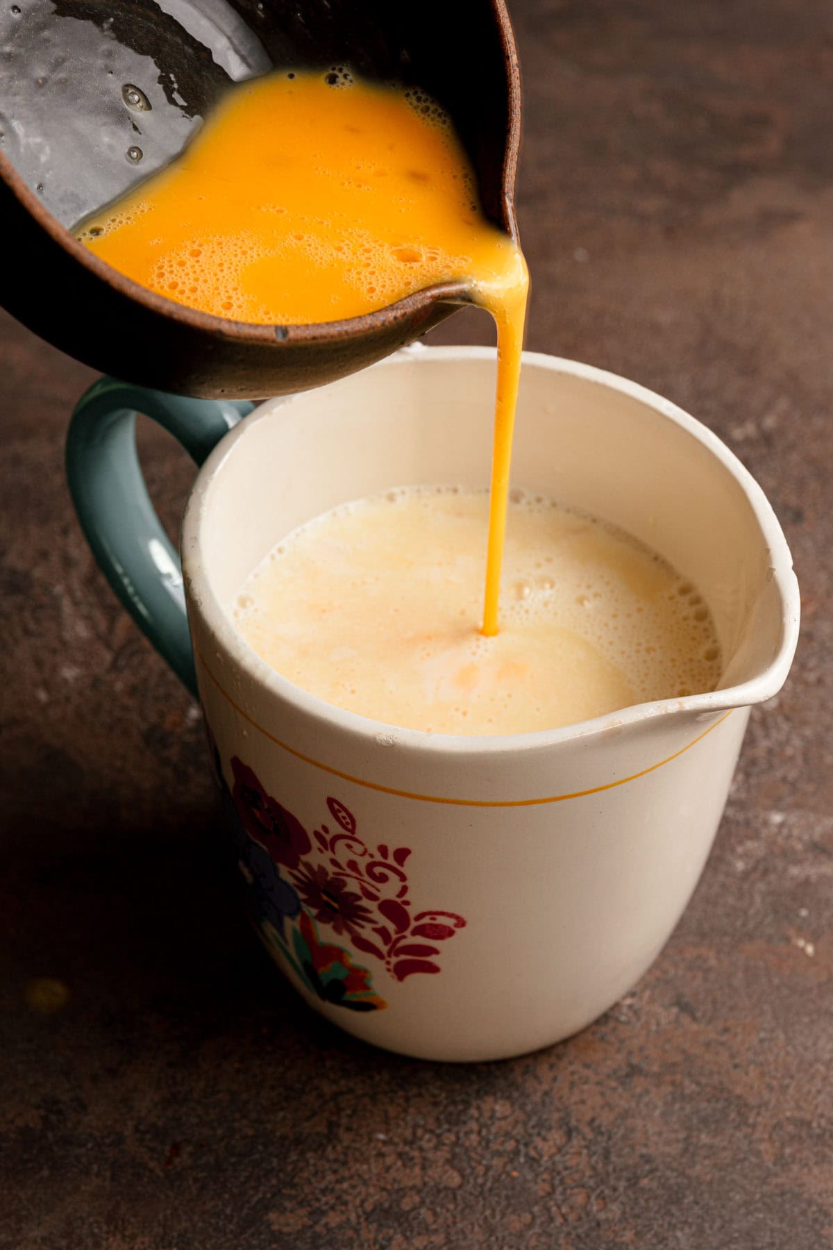 Pouring eggs into a milk mixture.