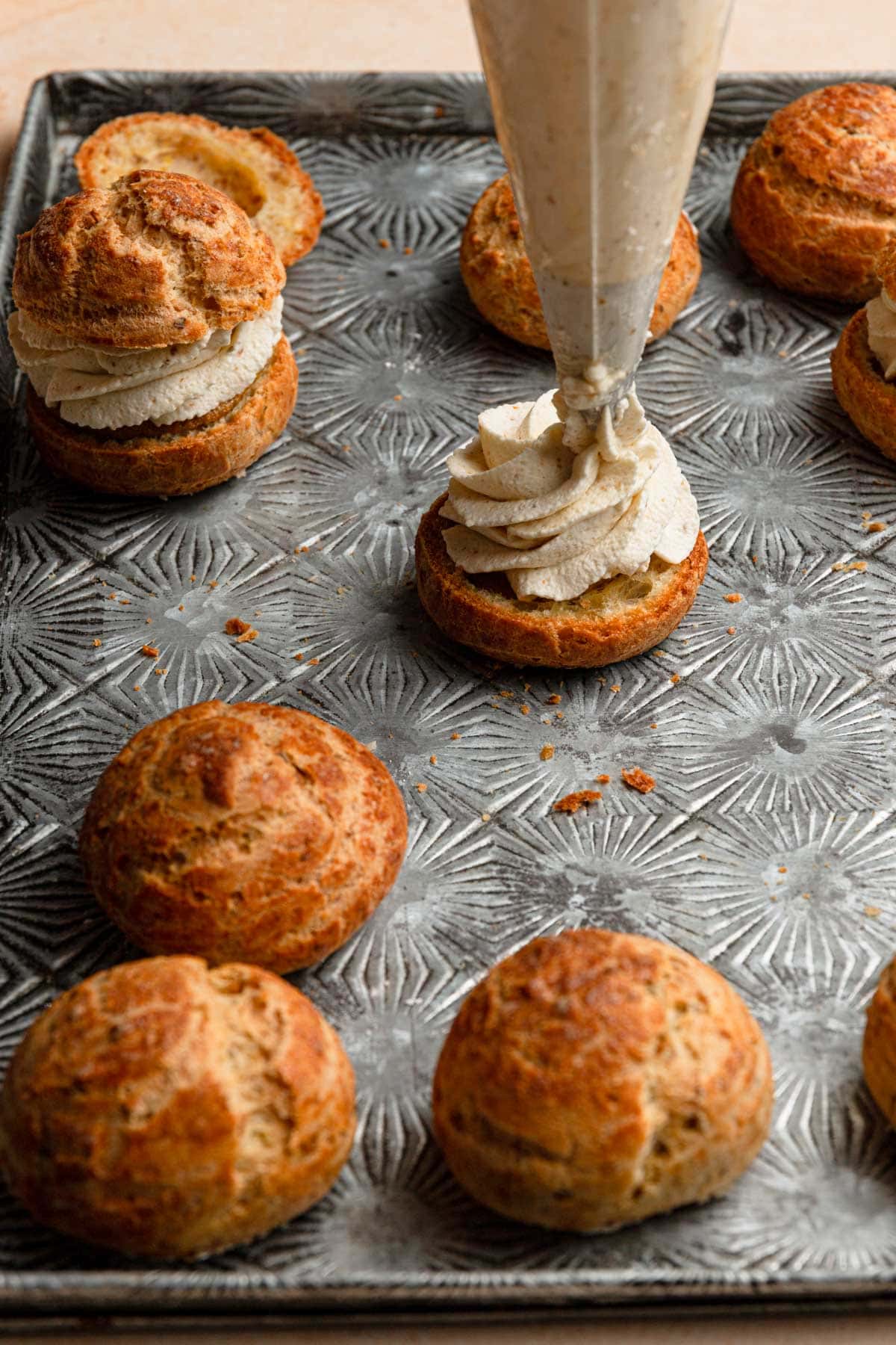 Piping cream over a cream puff.