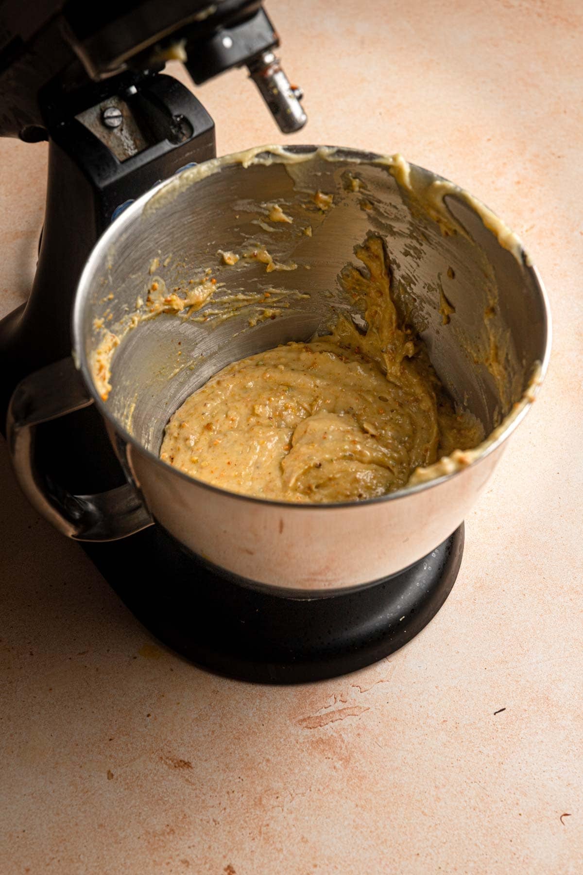 Pistachio choux paste in a mixer bowl.