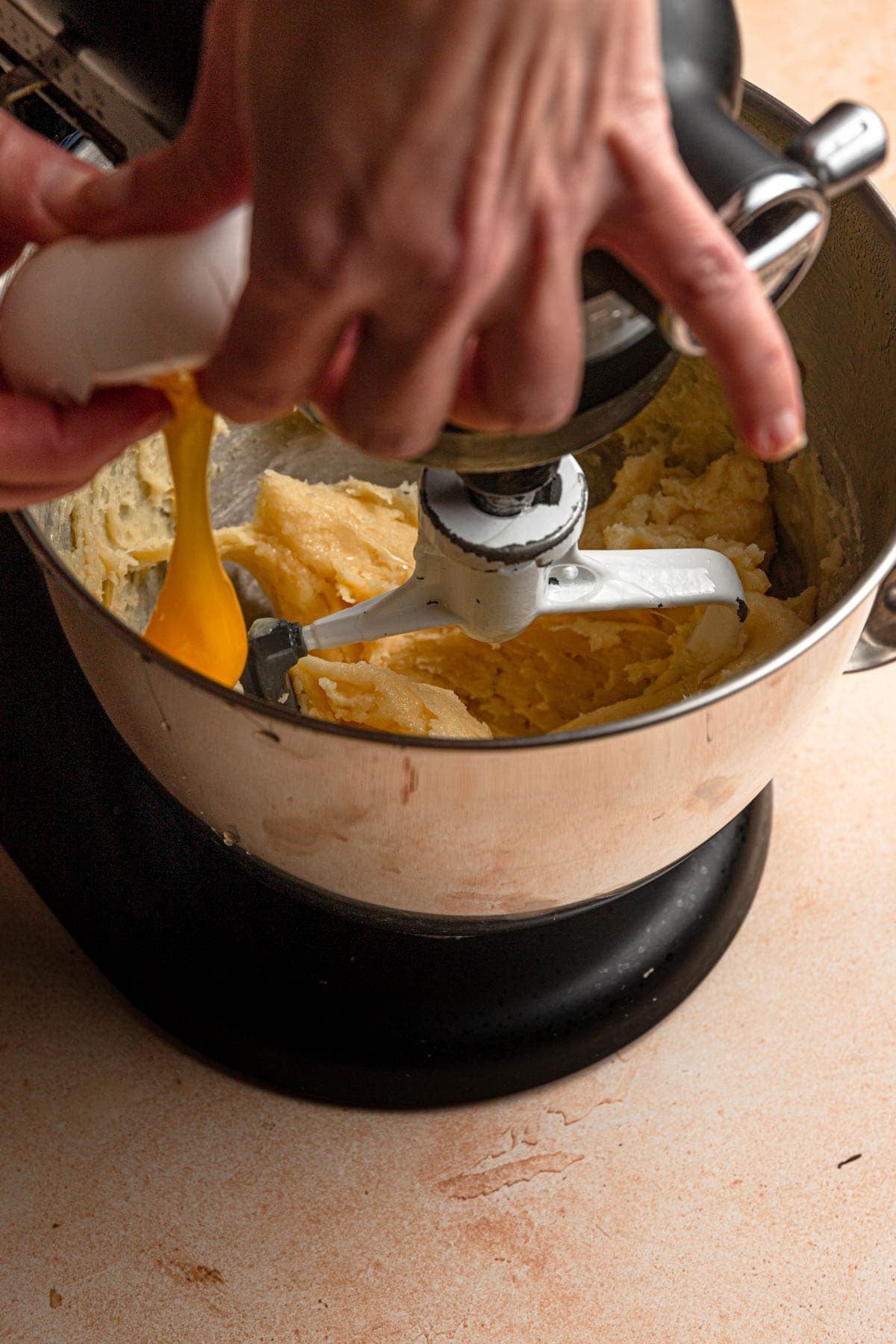 Adding eggs to cream puff dough.