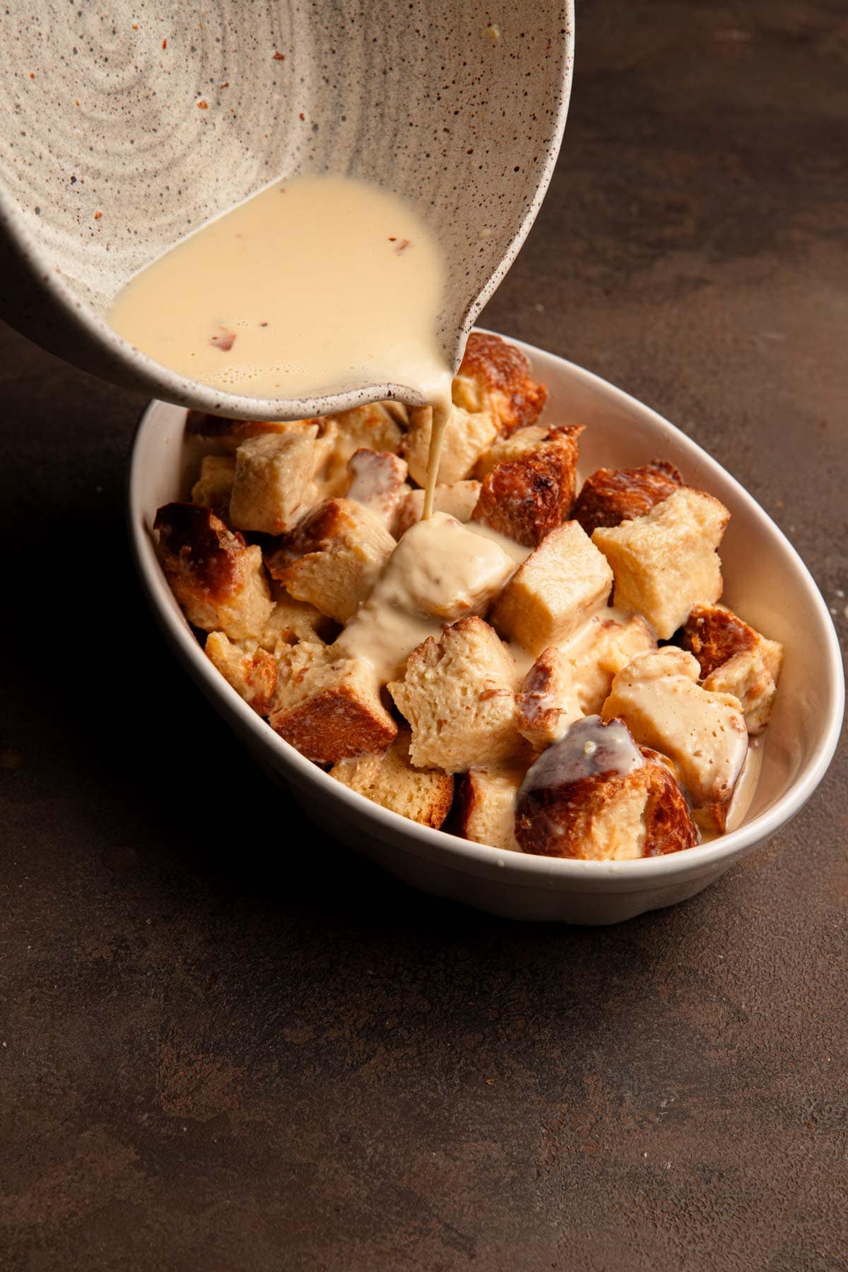 Pouring custard over brioche bread.
