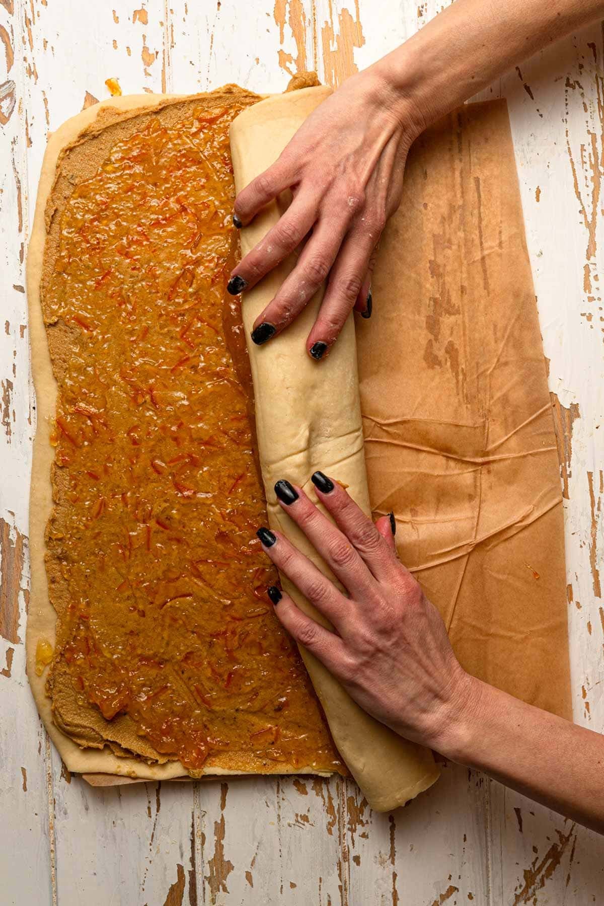 Hands rolling dough into a log.