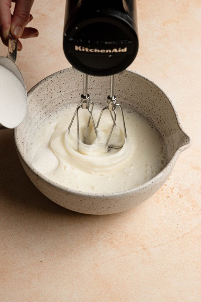 mixing egg whites while adding sugar.