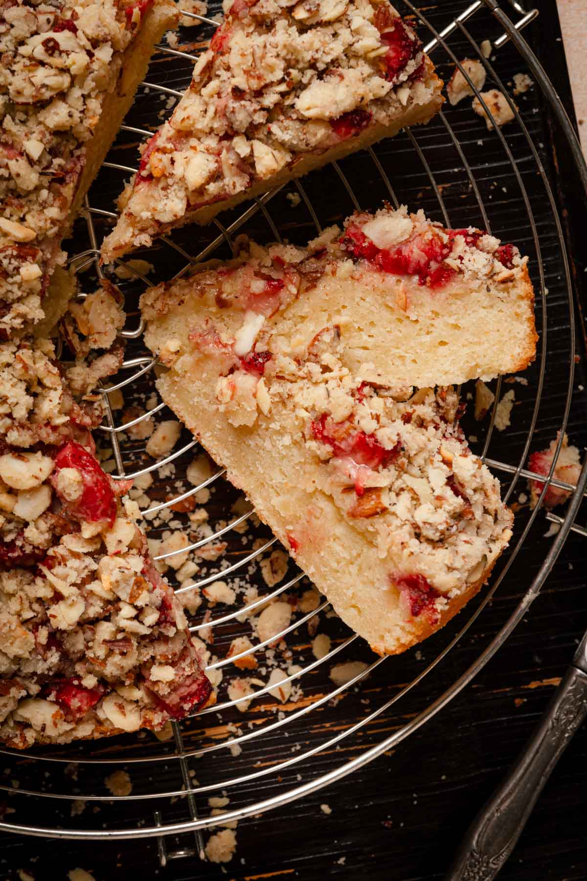 Sliced almond cake with streusel topping and strawberries.