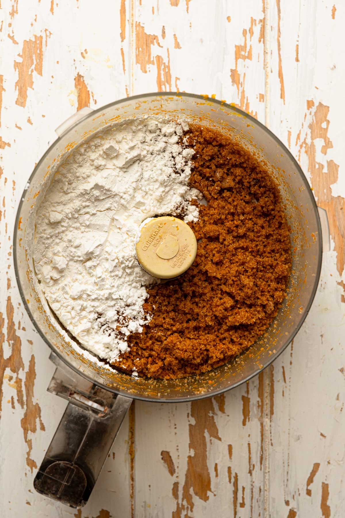 A food processor bowl with sugar and cornstarch.