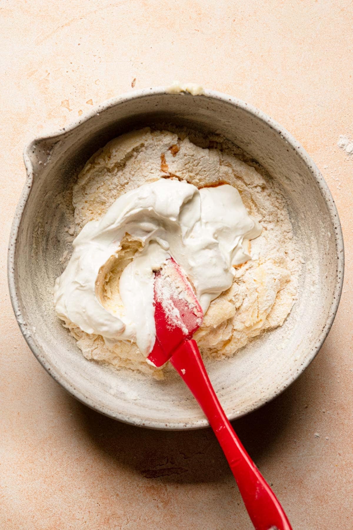 A bowl with a spatula mixing a cake batter.
