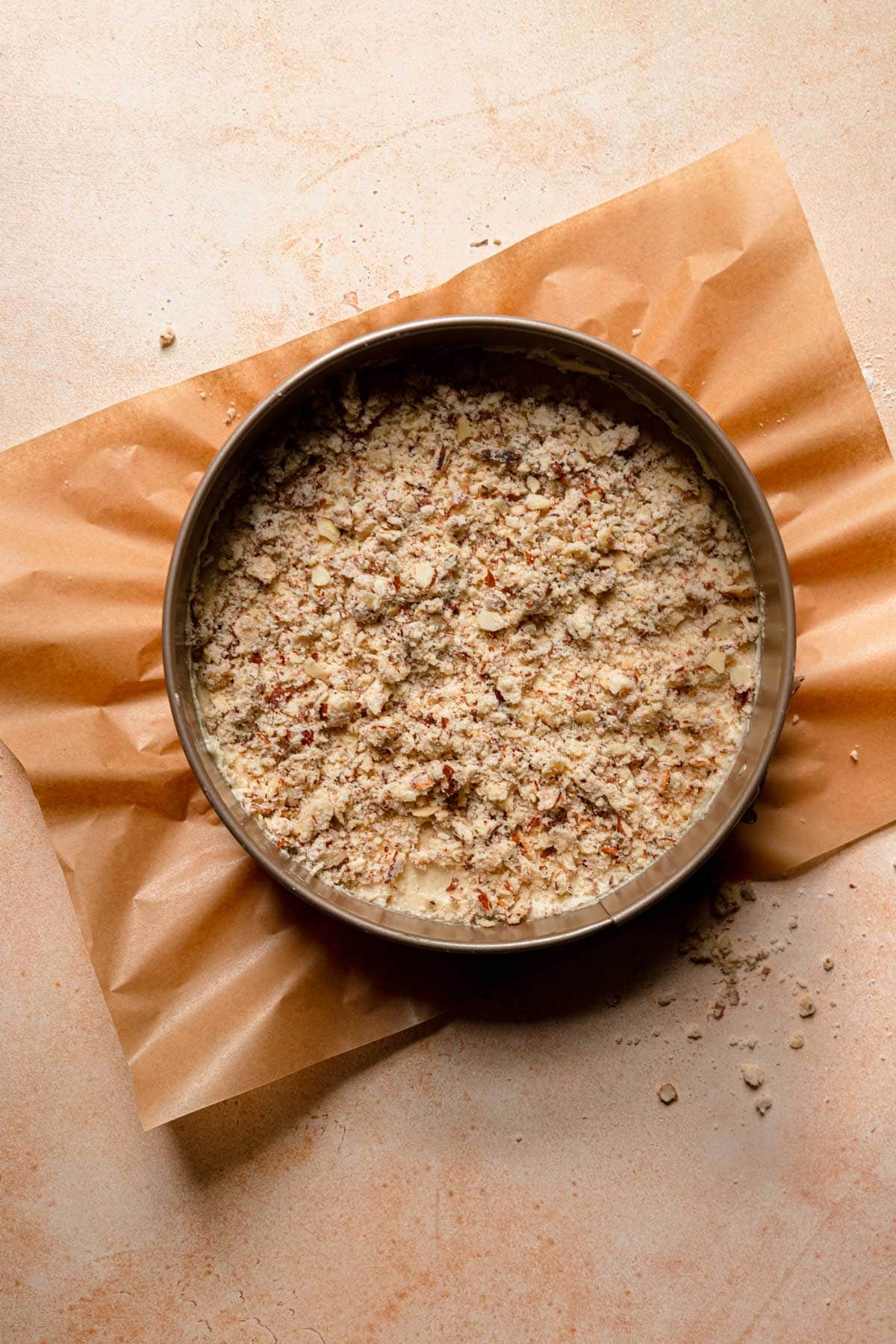 A pan with cake batter topped with crumble.