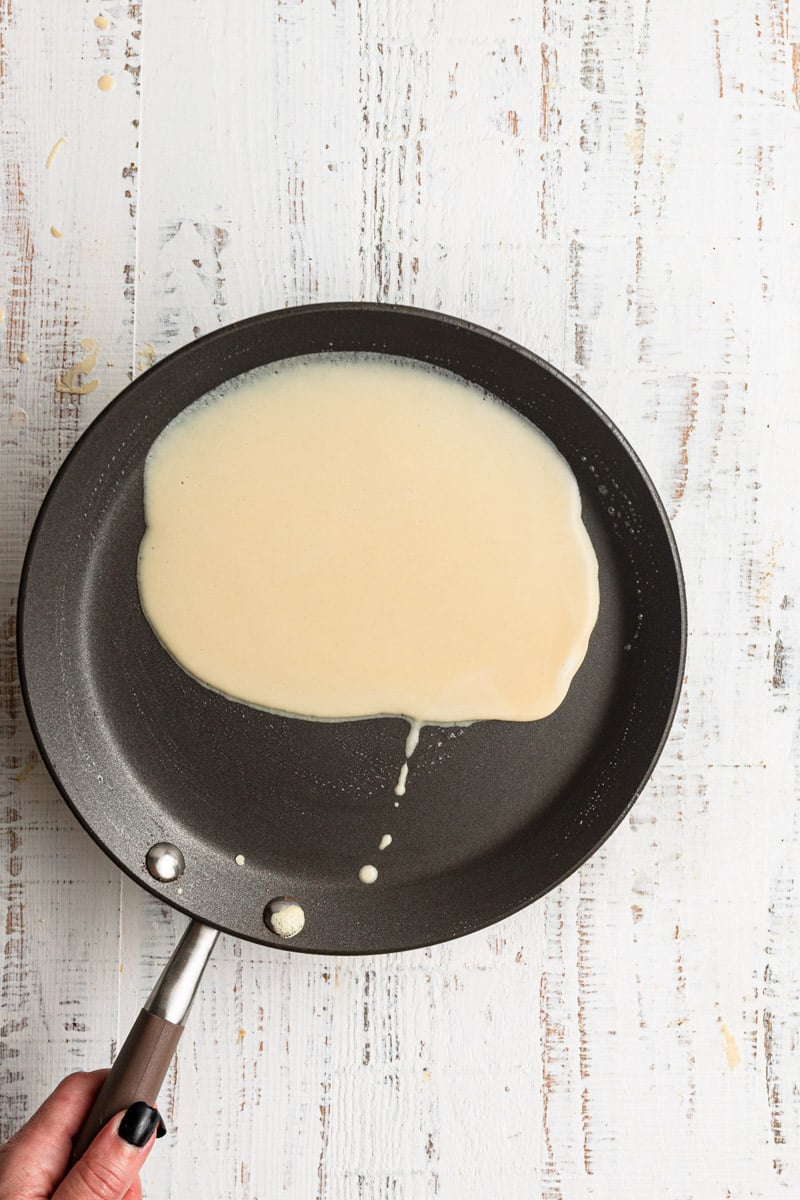 A skillet with crepe batter.