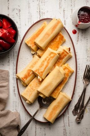 Cheese blintzes on an oval plate.
